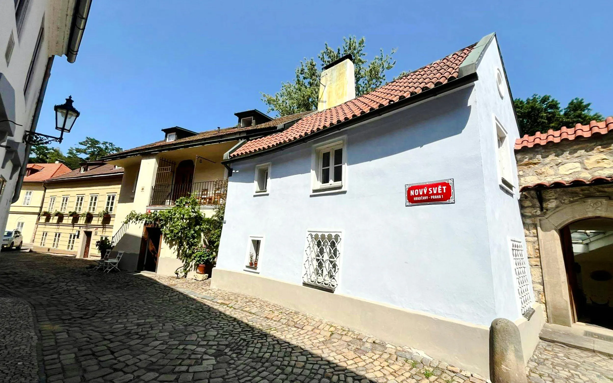 Nový Svět street in Hradčany, Prague, featuring historic buildings and cobblestone path.