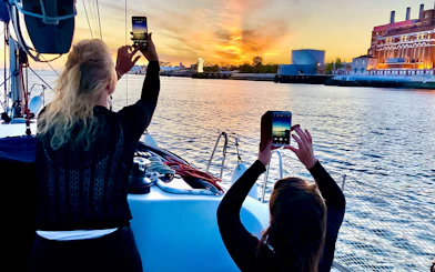 People photographing sunset on a Tagus River cruise in Lisbon.