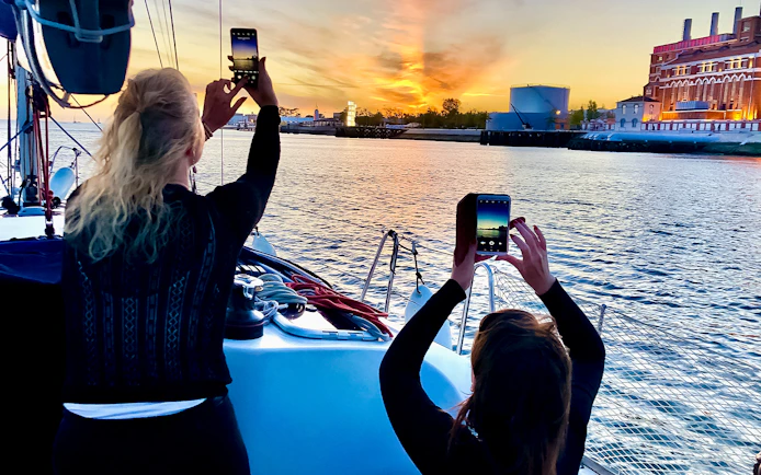 People photographing sunset on a Tagus River cruise in Lisbon.