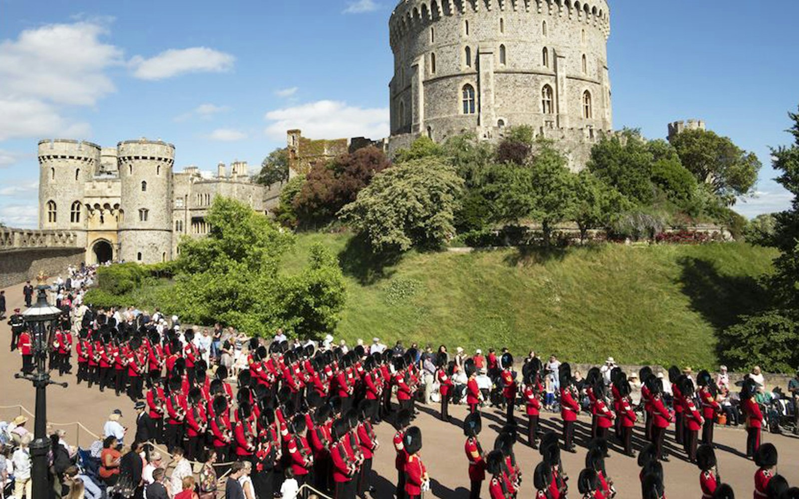 Windsor Castle with guards in red uniforms during a ceremonial event.