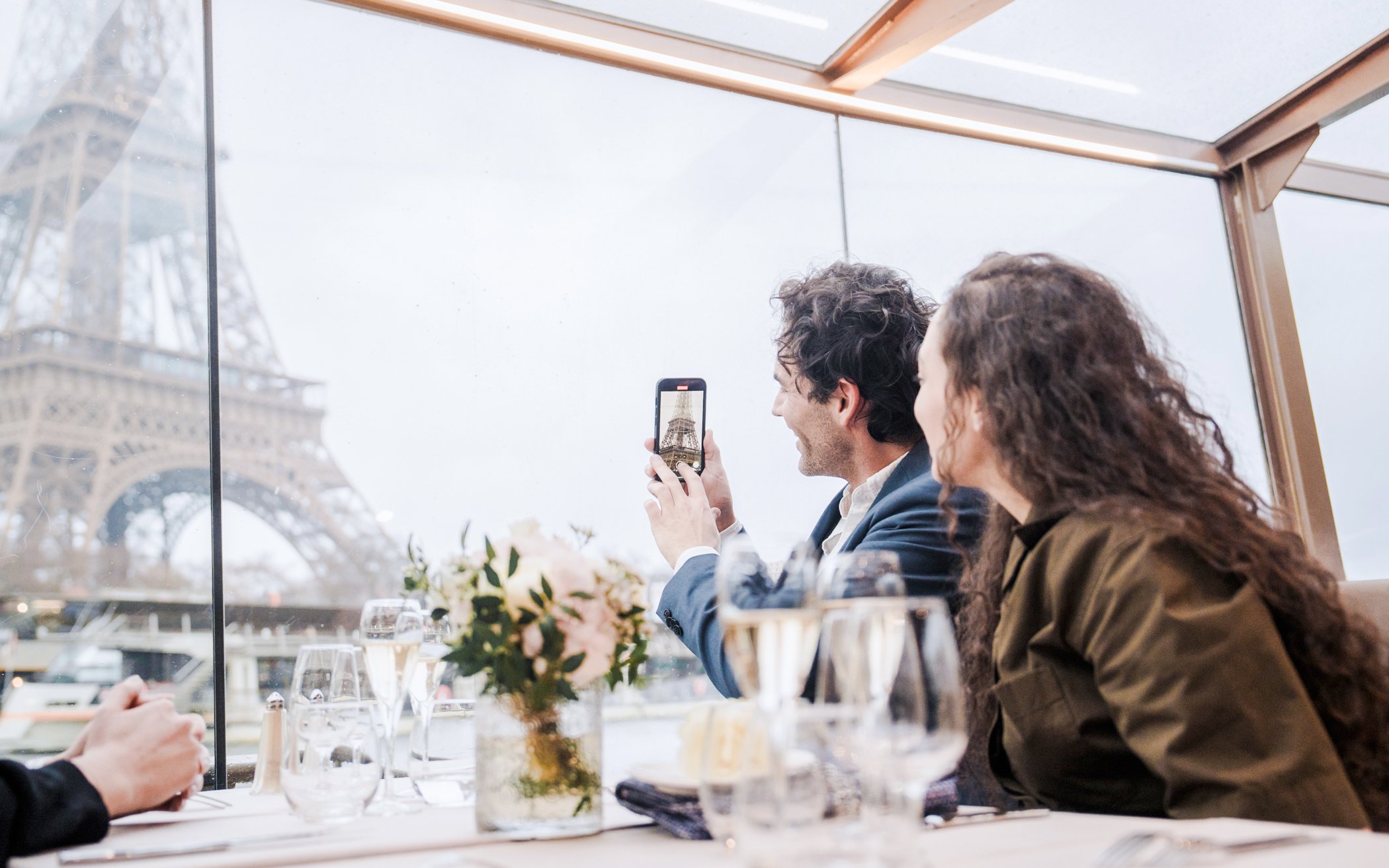 Couple enjoying Eiffel Tower view on Bateaux Mouches Seine River cruise.