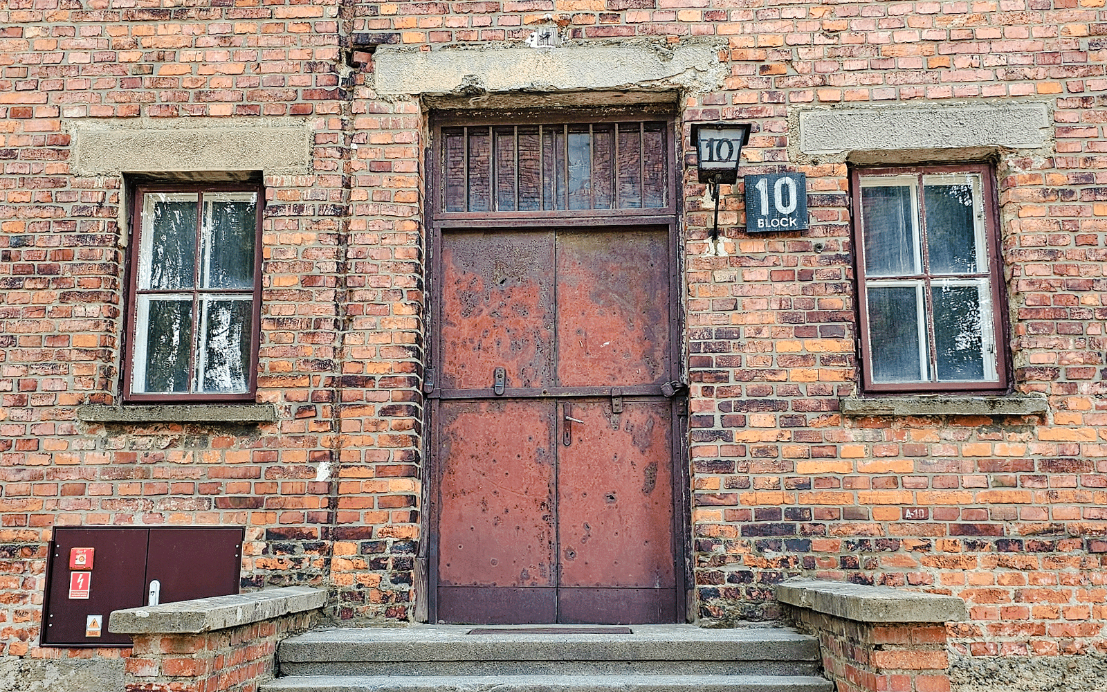 Barracks entrance at Auschwitz I, Block 10, with brick facade and metal door.