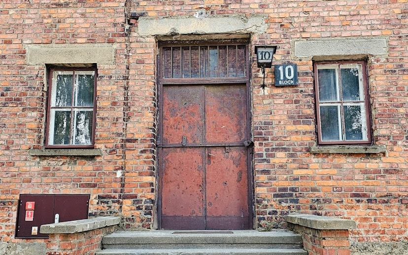 Barracks entrance at Auschwitz I, Block 10, with brick facade and metal door.