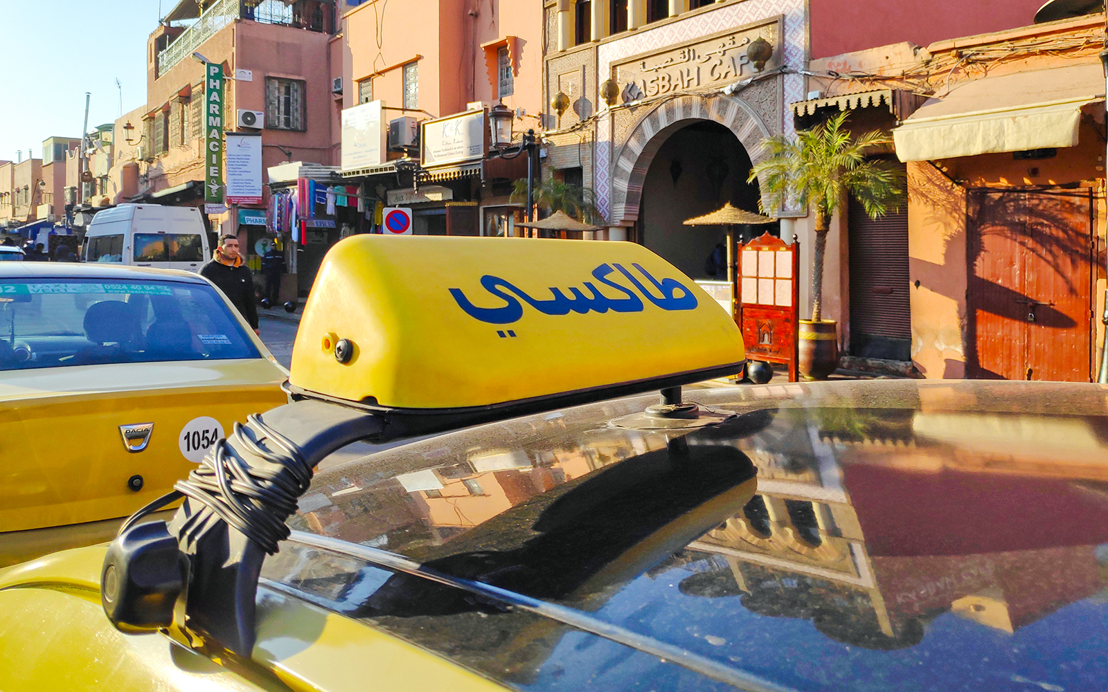 Yellow taxi in front of Asbah Café, Marrakech, Morocco.