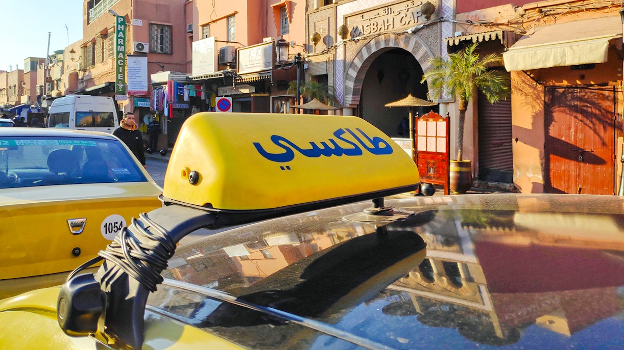 Yellow taxi in front of Asbah Café, Marrakech, Morocco.