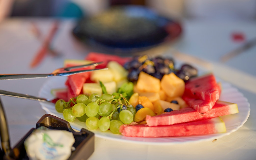 Plate of fresh fruits including watermelon, grapes, and melon on Langkawi day cruise lunch.