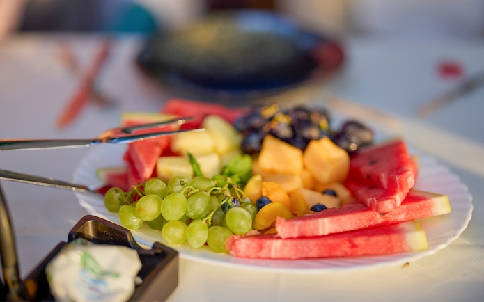 Plate of fresh fruits including watermelon, grapes, and melon on Langkawi day cruise lunch.