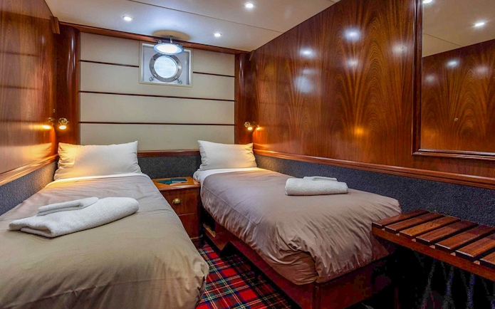 Cruise ship cabin with twin beds on Te Anau overnight tour.