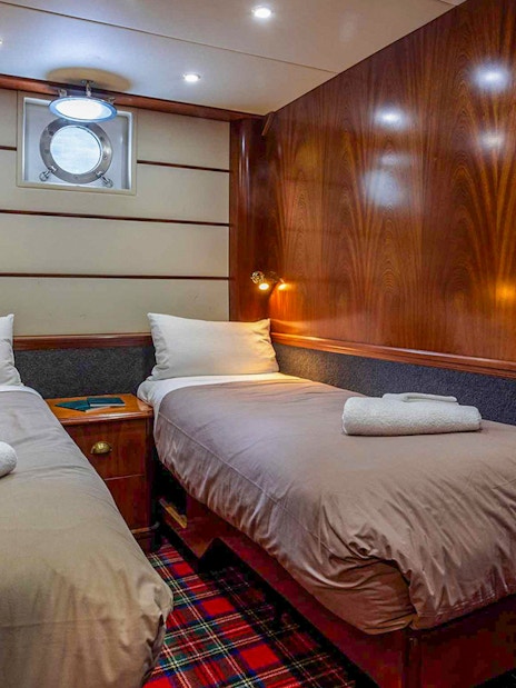 Cruise ship cabin with twin beds on Te Anau overnight tour.