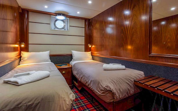 Cruise ship cabin with twin beds on Te Anau overnight tour.