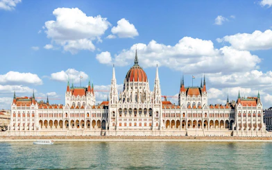Hungarian Parliament Building in Budapest with Danube River in foreground.