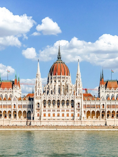 Hungarian Parliament Building in Budapest with Danube River in foreground.