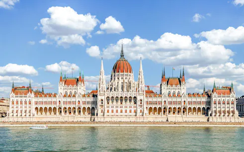 Hungarian Parliament Building in Budapest with Danube River in foreground.