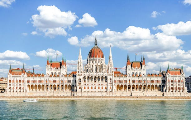 Hungarian Parliament Building in Budapest with Danube River in foreground.