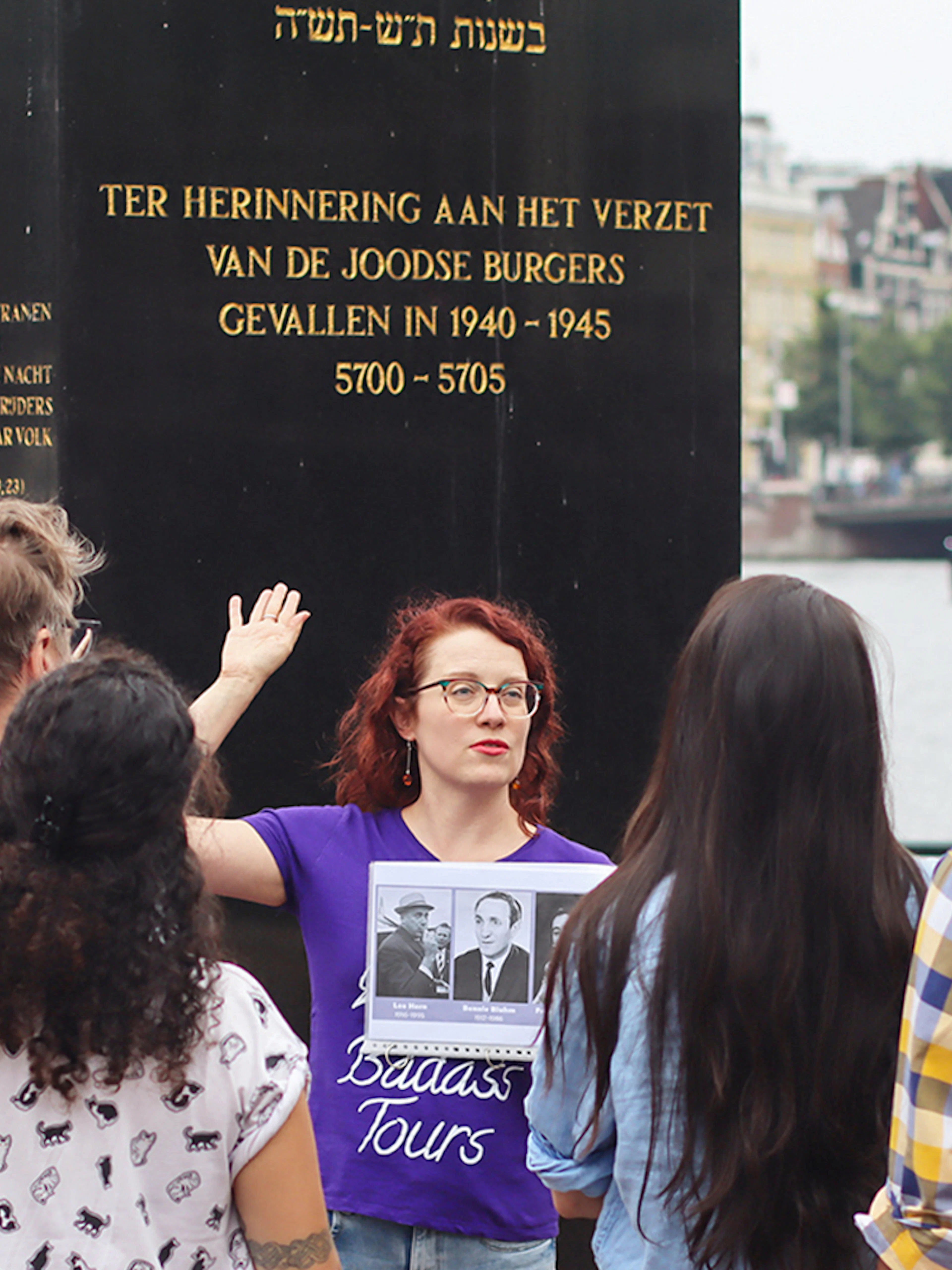 Group listening to a guide at a Jewish memorial in Amsterdam during a history tour.