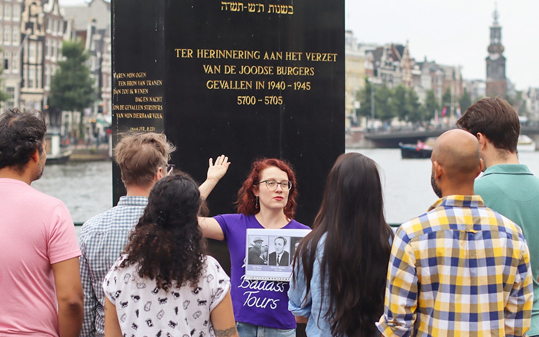Group listening to a guide at a Jewish memorial in Amsterdam during a history tour.