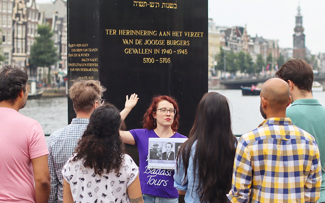 Group listening to a guide at a Jewish memorial in Amsterdam during a history tour.