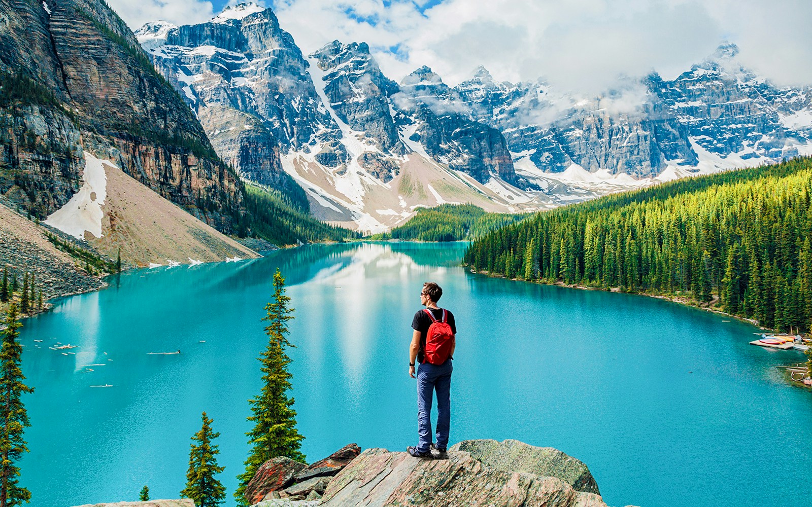 Person overlooking Moraine Lake with mountain backdrop, Banff National Park, Canadian Rockies.