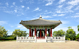 Traditional pavilion at Imjingak, Paju, South Korea, surrounded by trees and clear sky.