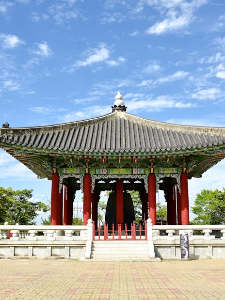 Traditional pavilion at Imjingak, Paju, South Korea, surrounded by trees and clear sky.