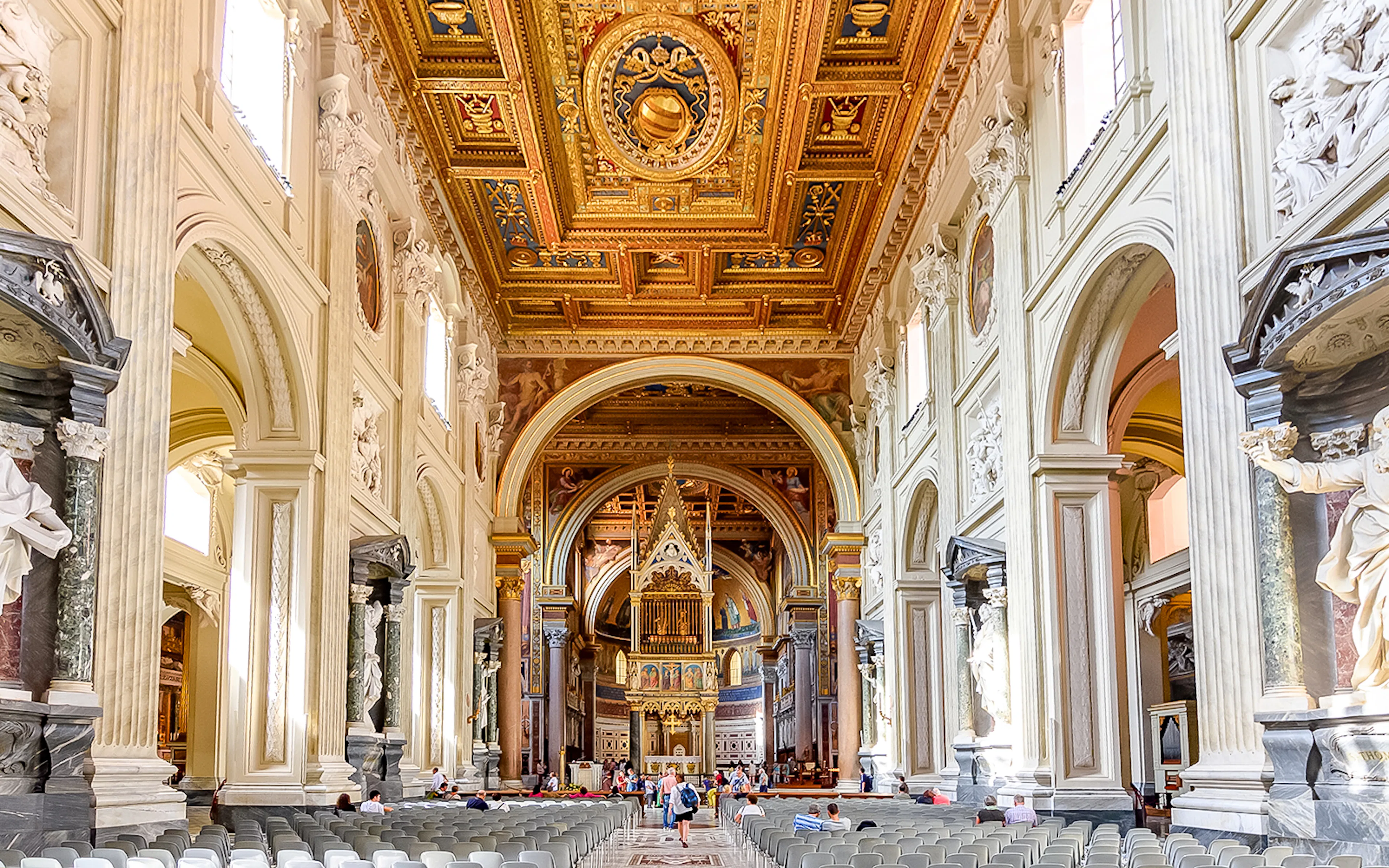 Five naves of the Archbasilica of St John Lateran with ornate ceiling and columns.