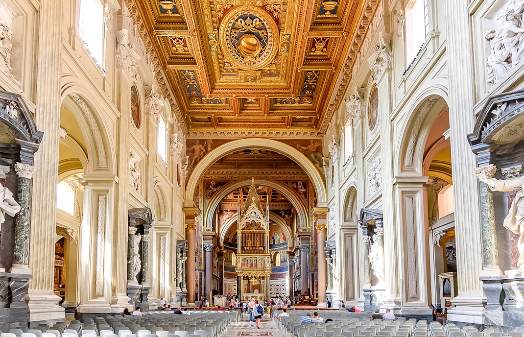 Five naves of the Archbasilica of St John Lateran with ornate ceiling and columns.