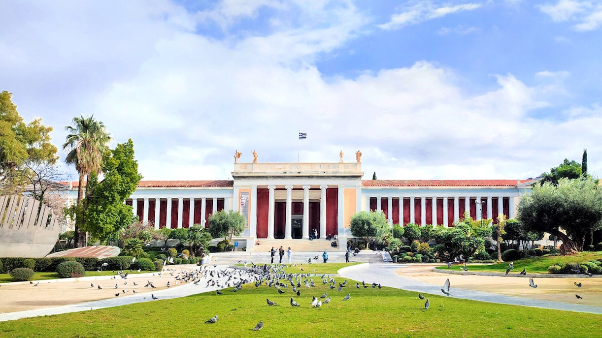 National Archaeological Museum facade with visitors and pigeons in Athens, Greece.