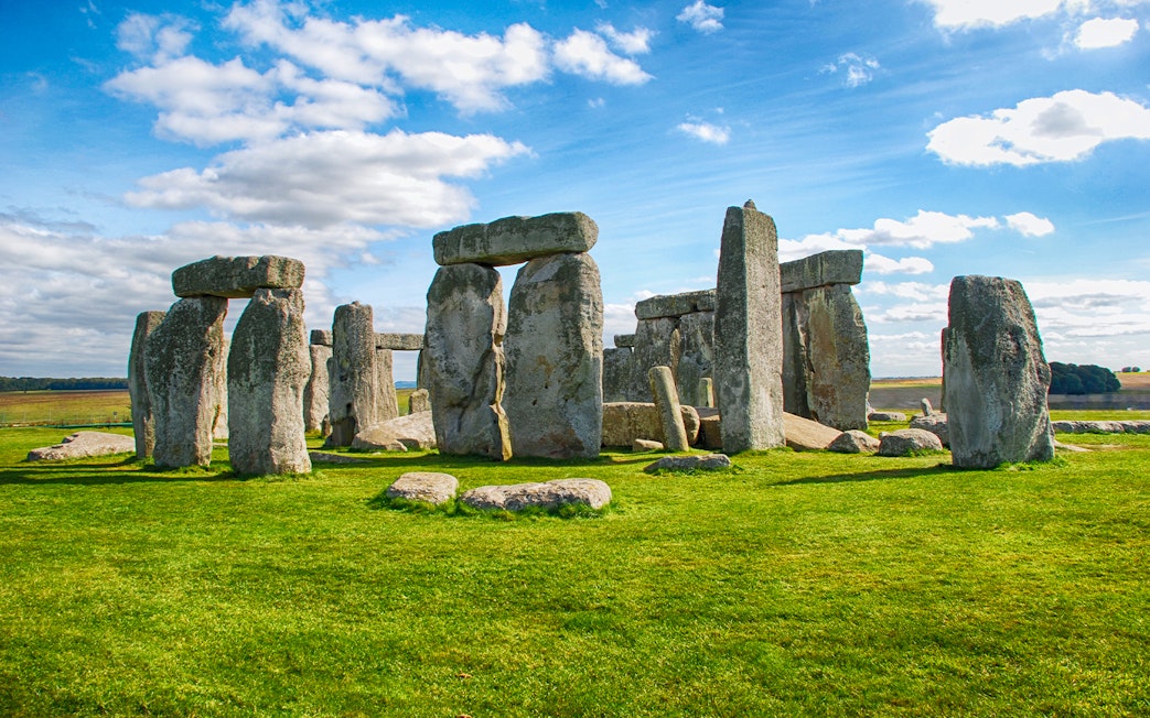Stonehenge with tourists exploring the ancient stone monument on a day trip from London.