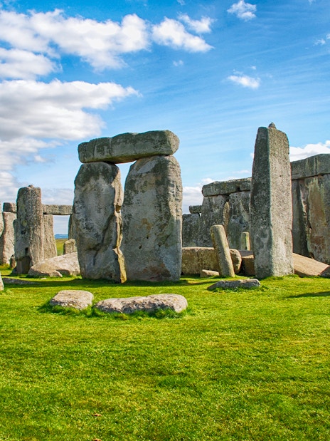 Stonehenge with tourists exploring the ancient stone monument on a day trip from London.