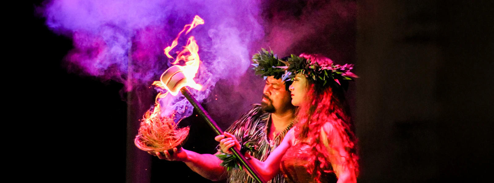 Performers at Moana Luau in Hawaii with fire and traditional attire.