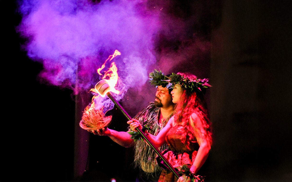 Performers at Moana Luau in Hawaii with fire and traditional attire.