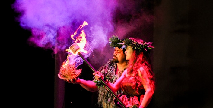 Performers at Moana Luau in Hawaii with fire and traditional attire.