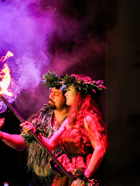 Performers at Moana Luau in Hawaii with fire and traditional attire.