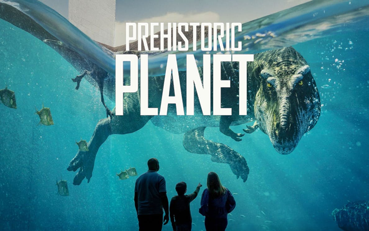 Family observing dinosaur underwater in Prehistoric Planet exhibit