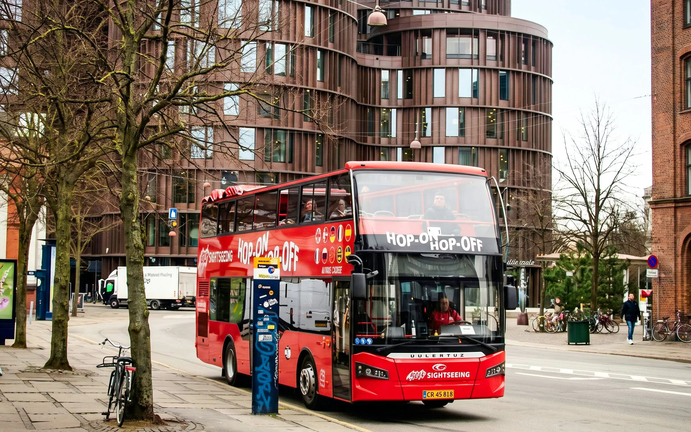 Red Sightseeing's Copenhagen hop-on hop-off bus near modern architecture.