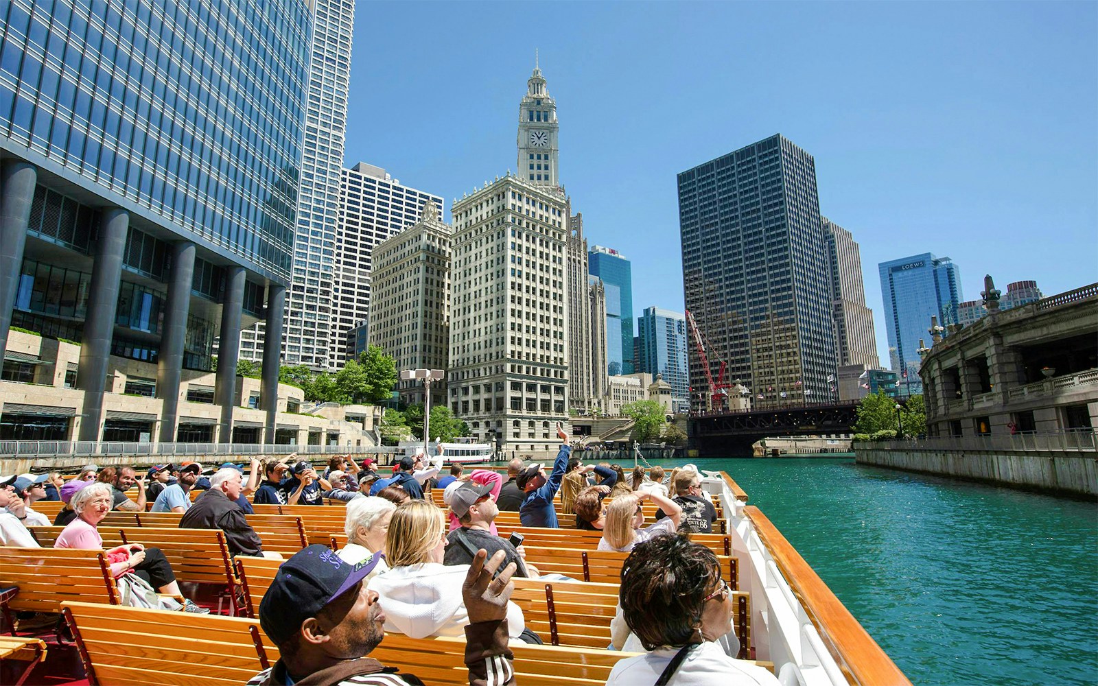 Visitors on Chicago River cruise viewing city architecture.