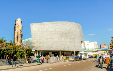 Bibliotheca Alexandrina exterior with hieroglyphic wall and ancient statue, Alexandria, Egypt.