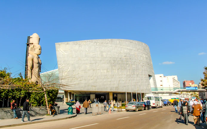 Bibliotheca Alexandrina exterior with hieroglyphic wall and ancient statue, Alexandria, Egypt.