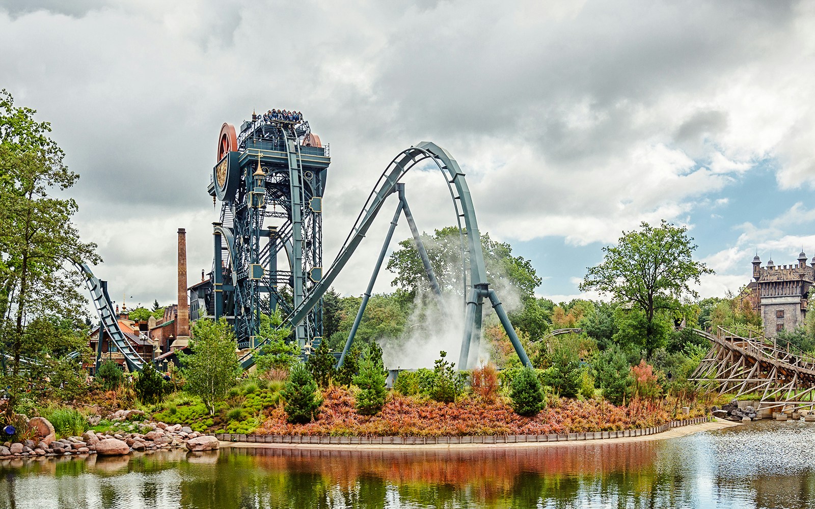 Dive coaster The Baron at Efteling amusement park, Netherlands, with riders and scenic surroundings.
