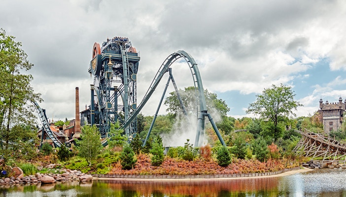 Dive coaster The Baron at Efteling amusement park, Netherlands, with riders and scenic surroundings.