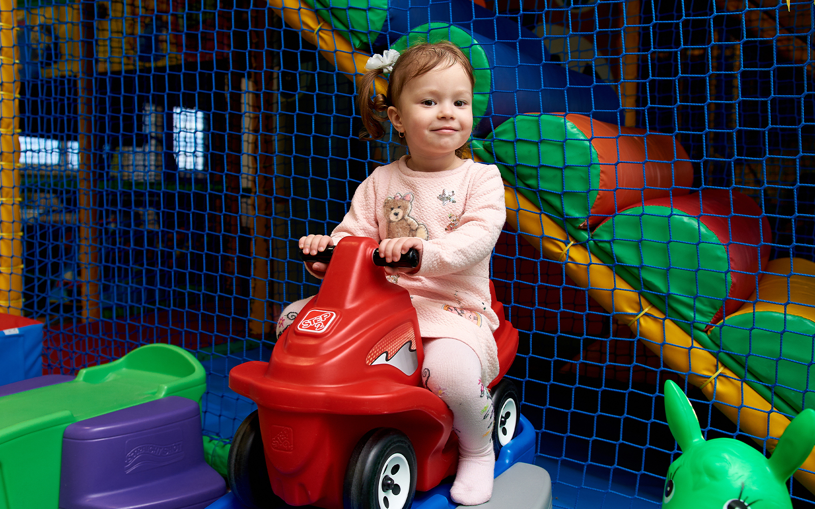 Cute little girl on run bike at kid zone