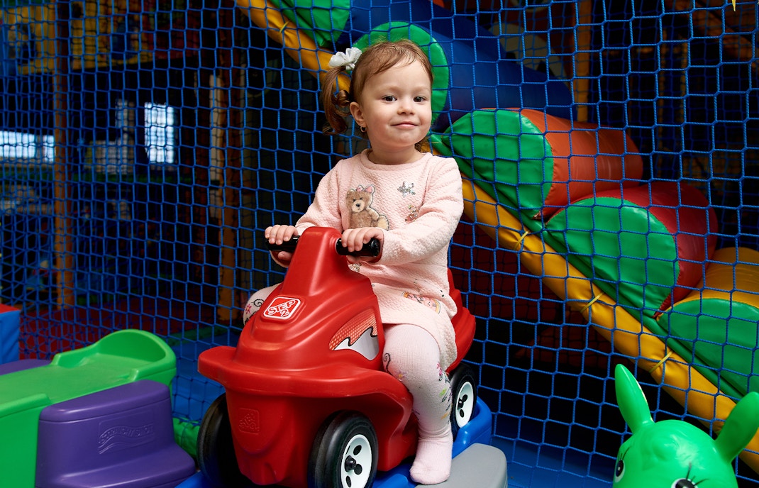 Cute little girl on run bike at kid zone