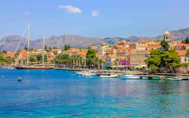 Coastal view of Cavtat, Croatia with boats and historic buildings.