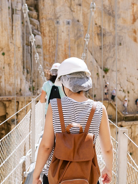 Visitors crossing a narrow bridge on the Caminito del Rey guided tour in Spain.
