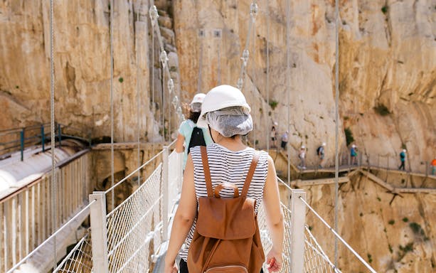 Visitors crossing a narrow bridge on the Caminito del Rey guided tour in Spain.