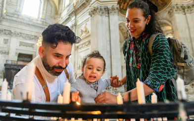 Visitors lighting candles inside St Paul's Cathedral, London.