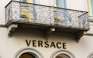 Versace store facade with ornate balcony in Milan.