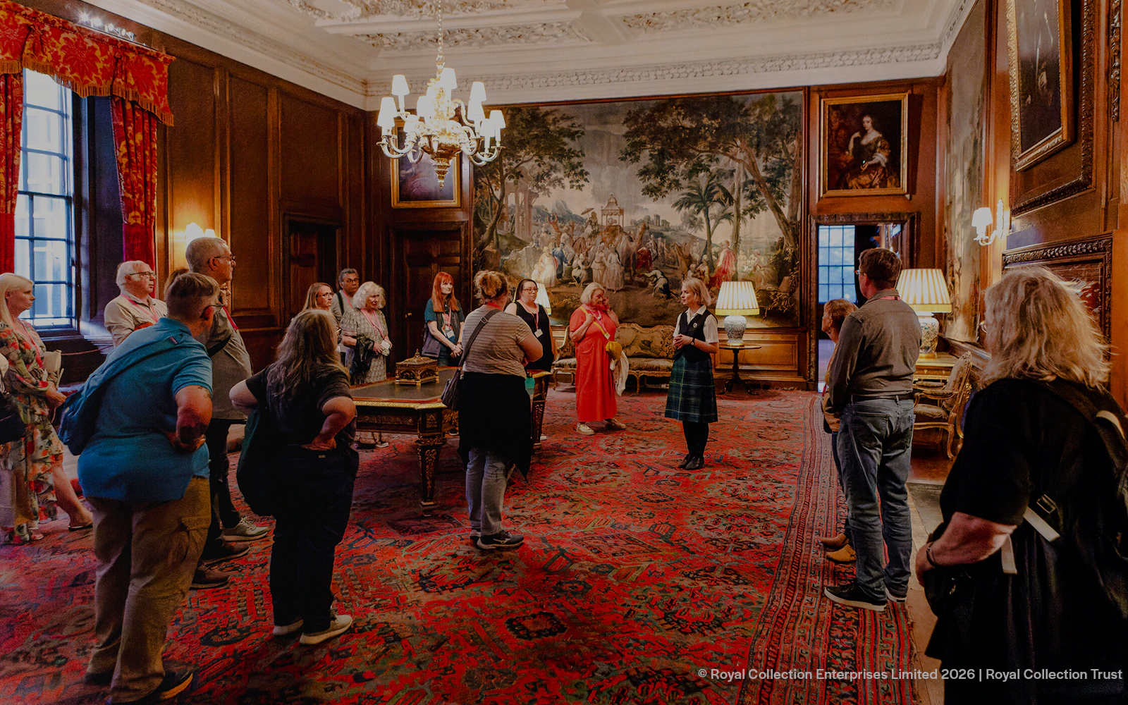 Visitors on a guided tour inside the ornate room of Palace of Holyroodhouse, Edinburgh.