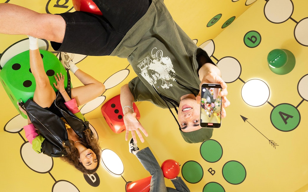 Visitors enjoying The Upside Down Berlin exhibit with colorful dice and playful decor.