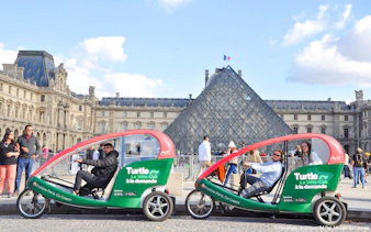 Turtle transport vehicles in front of the Louvre Pyramid, Paris.